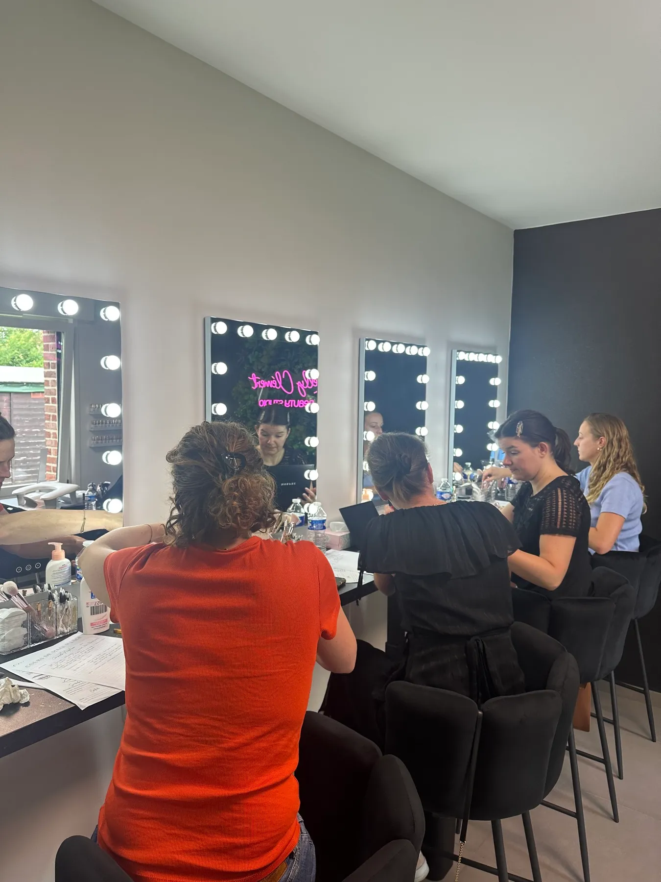Plusieurs participantes apprenant à se maquiller ensemble au Studio