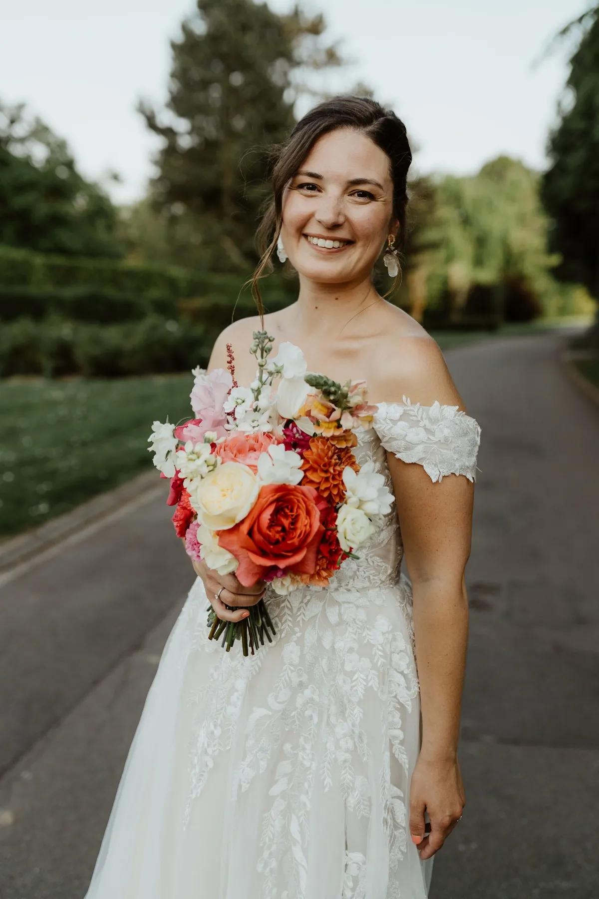 Mariée souriante avec son bouquet, maquillage naturel et lumineux