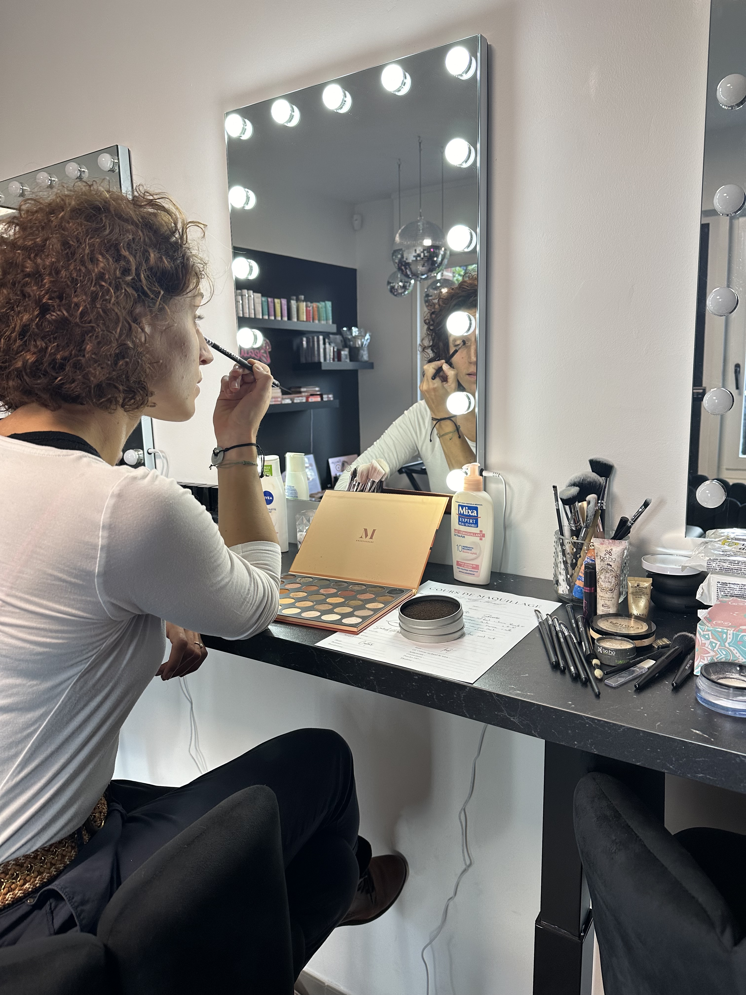 Cours de maquillage au studio devant un miroir lumineux